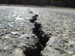 Deep crack in asphalt that is in need of crack sealing and seal coating repair